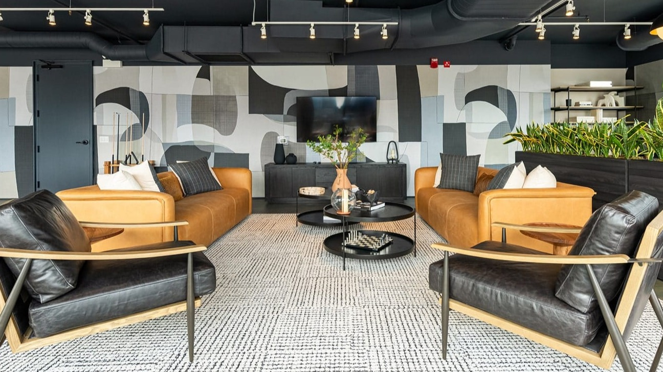Contemporary resident lounge at The Jax in Chicago, featuring stylish seating, modern art, and a large flat-screen TV