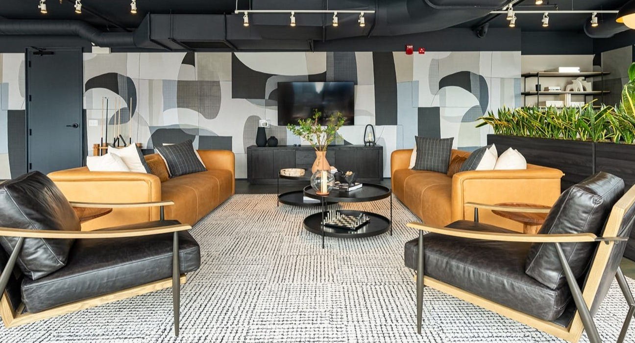 Contemporary resident lounge at The Jax in Chicago, featuring stylish seating, modern art, and a large flat-screen TV