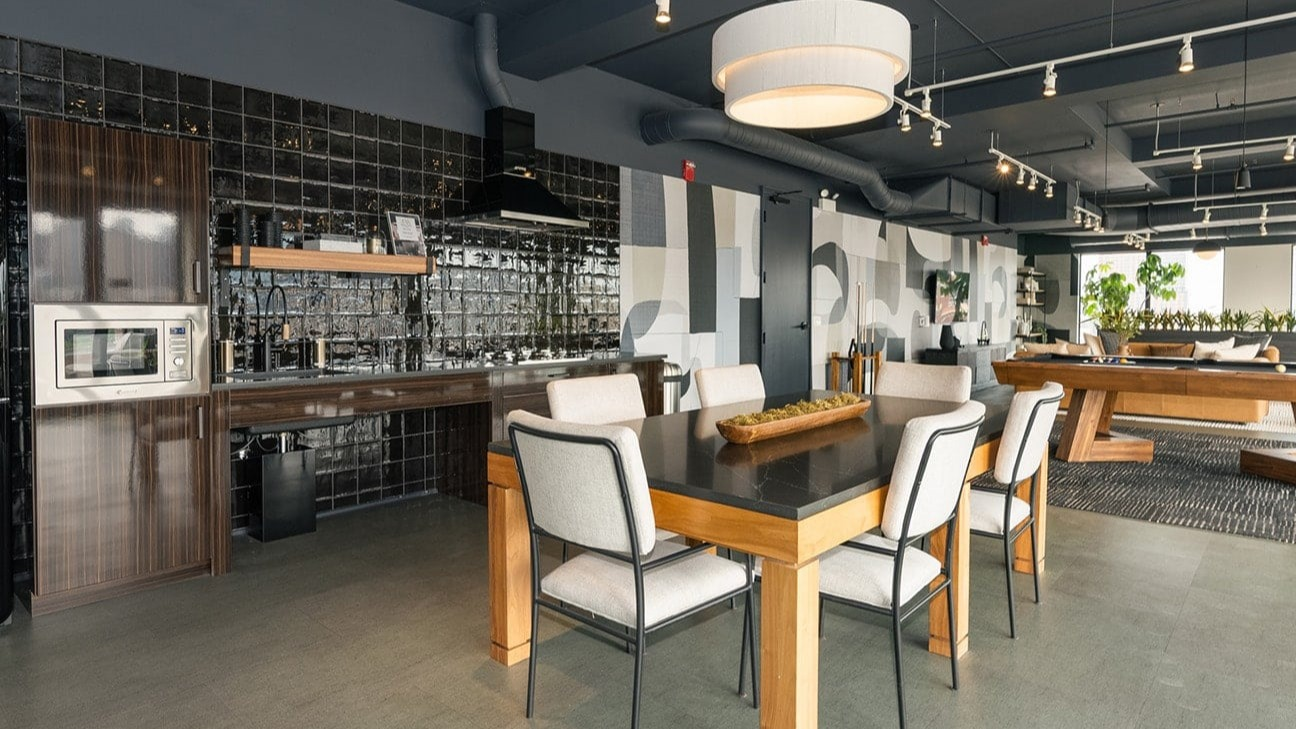 Vibrant resident lounge at The Jax in Chicago, featuring a stylish dining area, billiards table, and a modern kitchenette