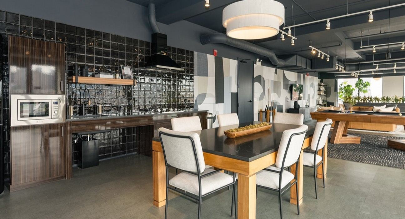 Vibrant resident lounge at The Jax in Chicago, featuring a stylish dining area, billiards table, and a modern kitchenette
