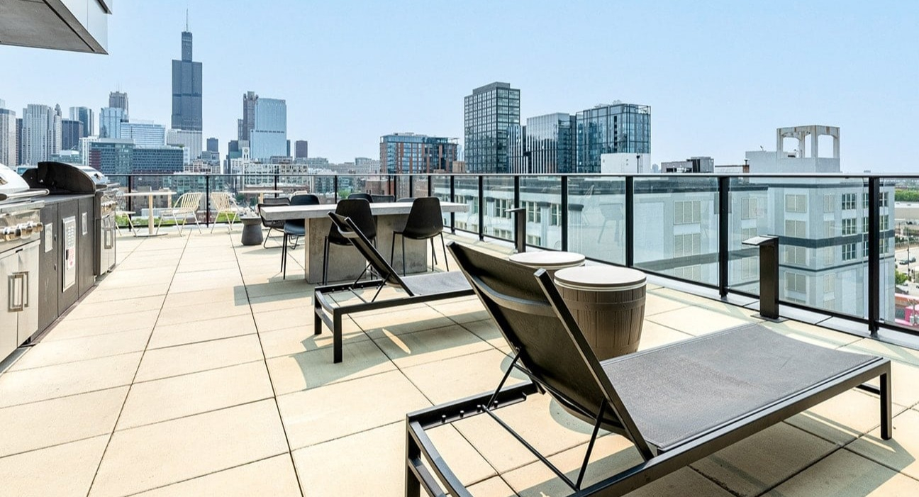 Expansive rooftop deck at The Jax in Chicago, featuring grilling stations, lounge chairs, and stunning city views