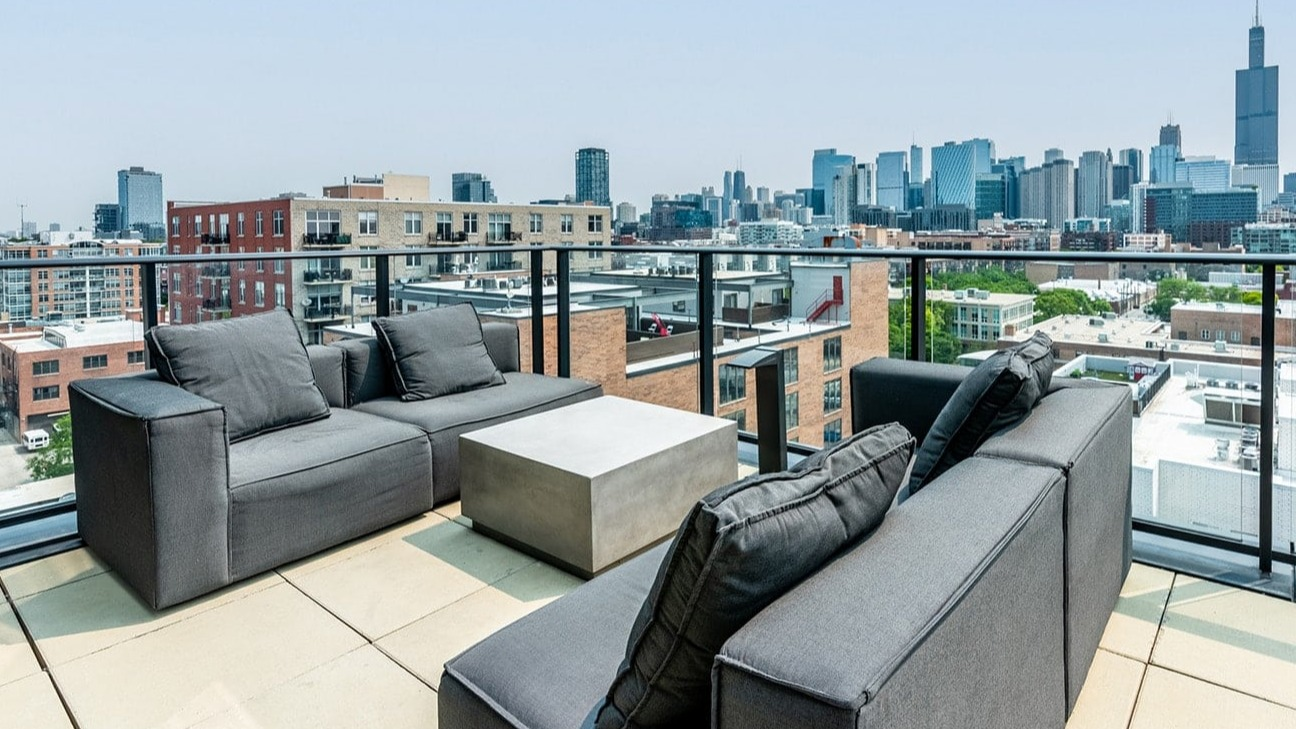 Luxurious rooftop lounge at The Jax in Chicago, featuring modern outdoor sofas and breathtaking city skyline views