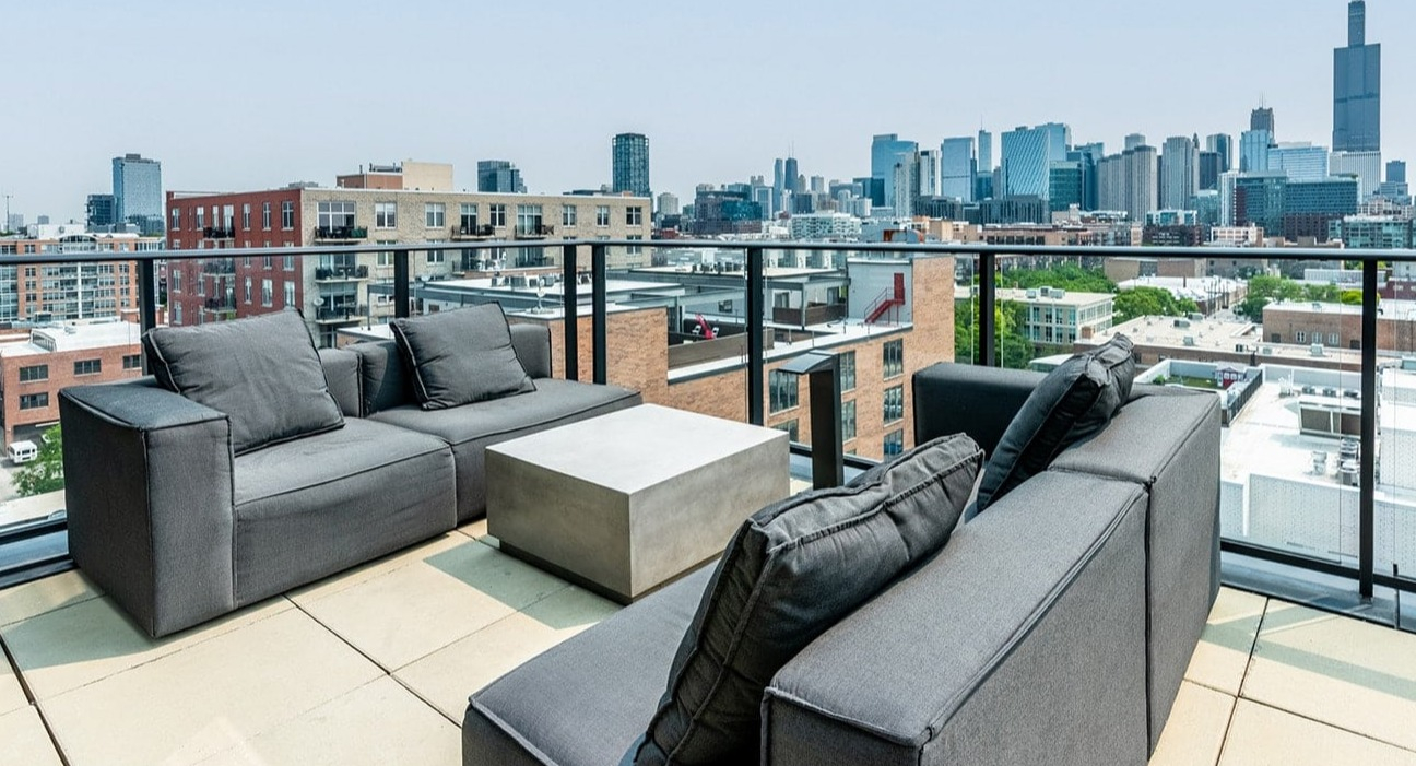 Luxurious rooftop lounge at The Jax in Chicago, featuring modern outdoor sofas and breathtaking city skyline views