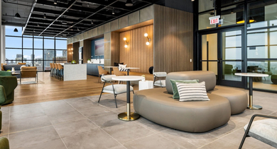 Expansive clubroom at The Leo in Chicago, featuring diverse seating arrangements, co-working tables, and modern amenities