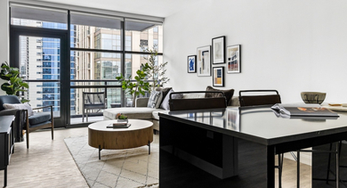 Contemporary open-concept living and dining area at The Leo in Chicago, featuring a comfortable sofa and a stylish dining table