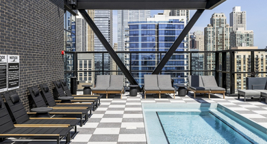 Inviting poolside lounge area at The Leo in Chicago, featuring comfortable chairs and breathtaking city skyline views