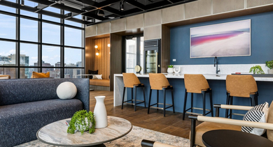 Modern resident lounge at The Leo in Chicago, featuring comfortable seating, a sleek bar area, and large windows with city views