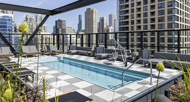 Stunning rooftop pool at The Leo in Chicago, featuring a checkered deck, lounge seating, and impressive skyline views