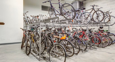 A spacious and organized bike storage room with multiple racks, offering convenient amenity for residents at The Madison at Racine in Chicago