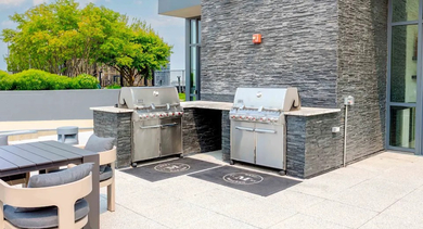 Multiple high-end grilling stations with counter space on the rooftop deck, perfect for entertaining at The Madison at Racine in Chicago