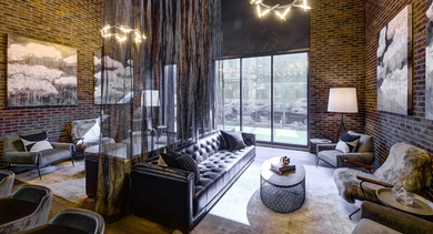 A stunning grand lobby lounge with high ceilings, exposed brick walls, plush seating, and artistic lighting fixtures at The Mason in Chicago