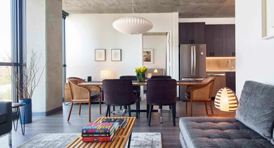 An inviting open-concept apartment with a comfortable living area, a modern dining space, and large windows at The Mason in Chicago