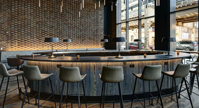 A stylish resident lounge featuring a large circular bar with seating, perfect for co-working or socializing at The Mason in Chicago
