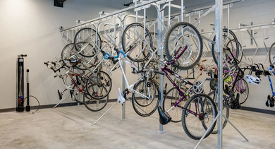 A well-organized bike storage room with multiple racks, communal air pumps, and tools for residents at The Mason in Chicago