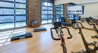 A bright and spacious spin studio equipped with multiple exercise bikes, fitness balls, and large windows for invigorating workouts at The Mason in Chicago