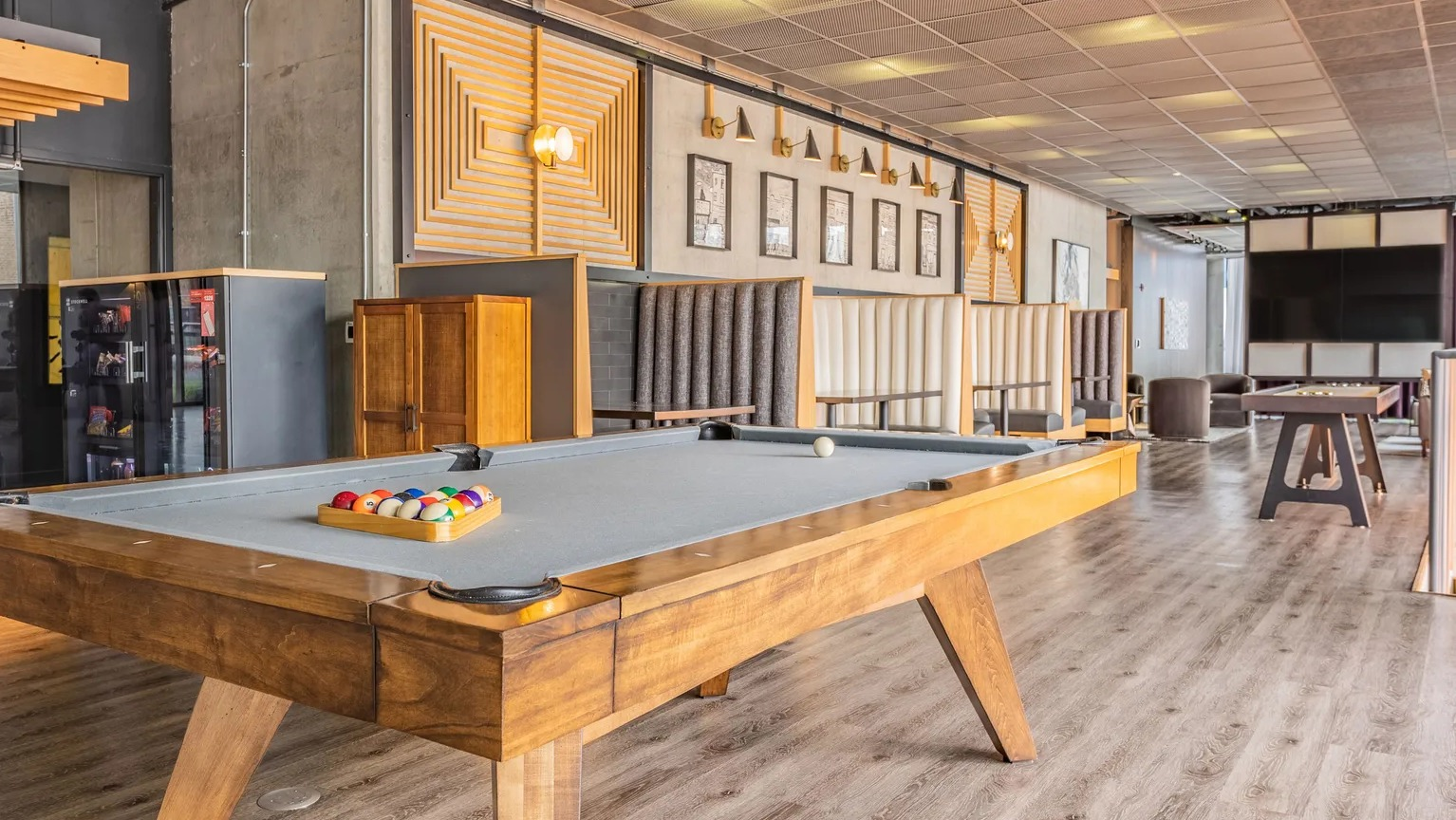 A lively game room with a billiards table, comfortable seating areas, and modern decor for resident entertainment at The Parker Fulton Market in Chicago