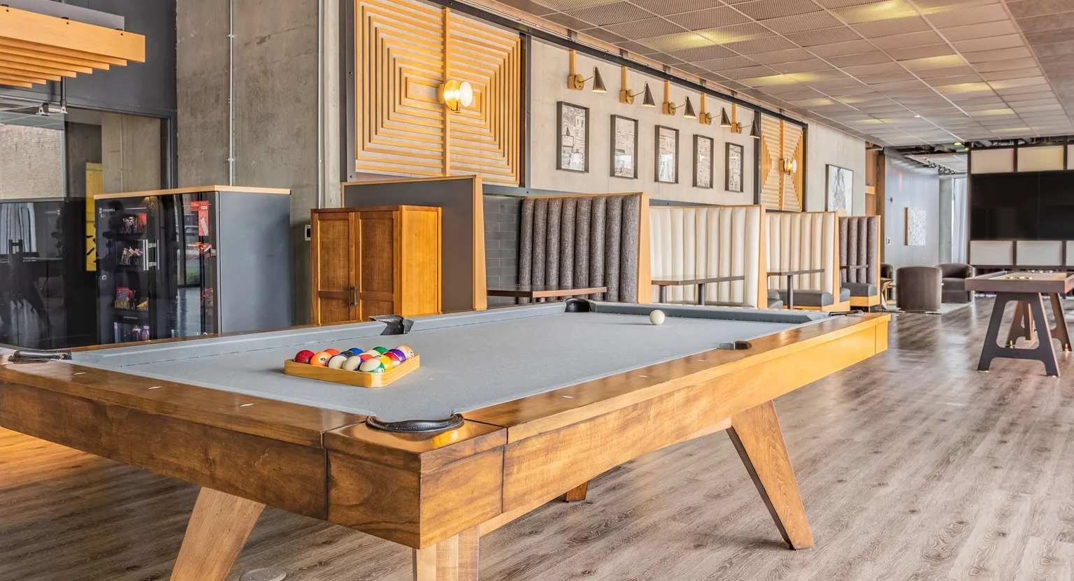 A lively game room with a billiards table, comfortable seating areas, and modern decor for resident entertainment at The Parker Fulton Market in Chicago