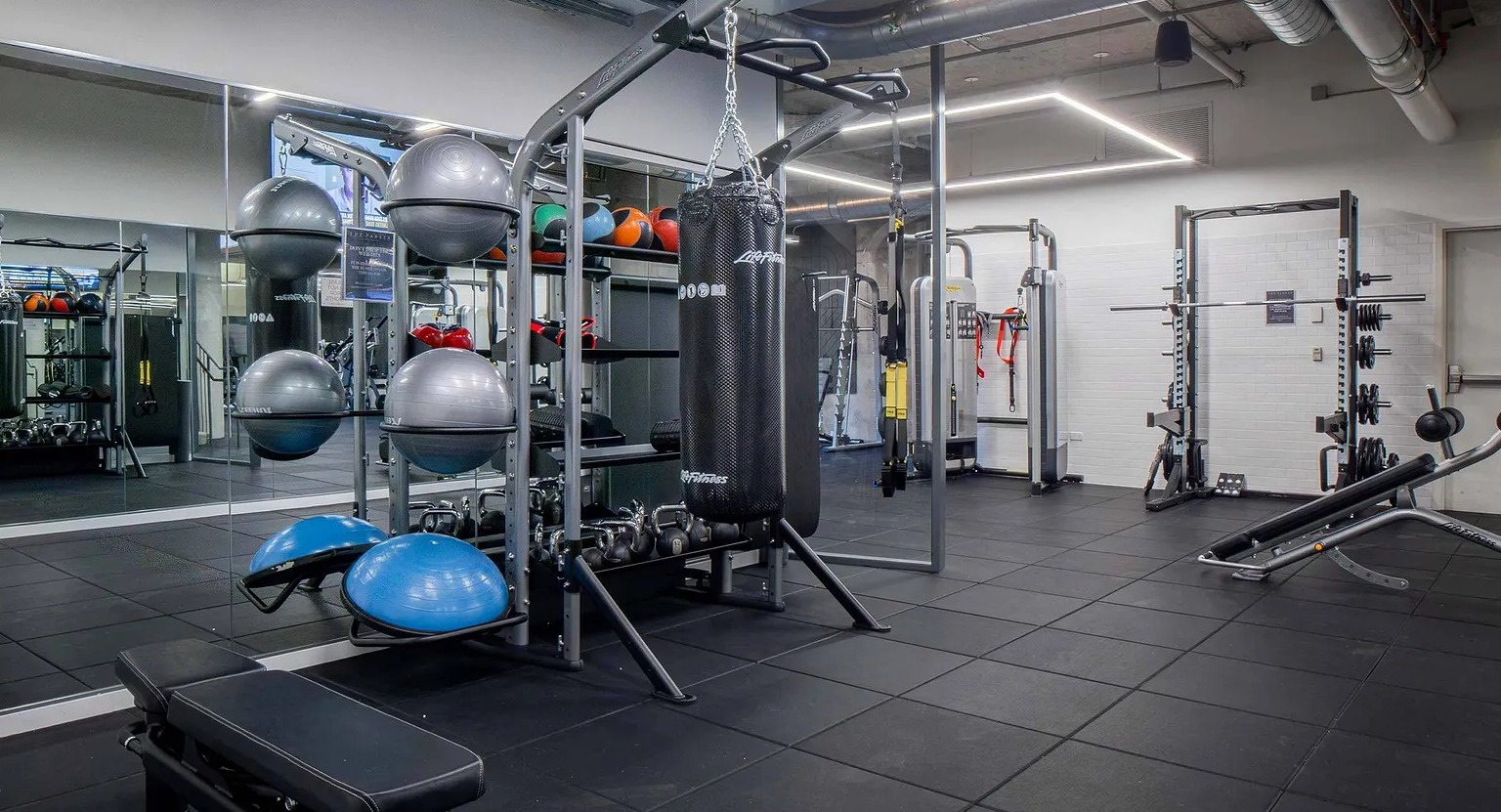 A dynamic gym space featuring a punching bag, functional training equipment, and free weights, perfect for diverse workouts at The Parker Fulton Market in Chicago