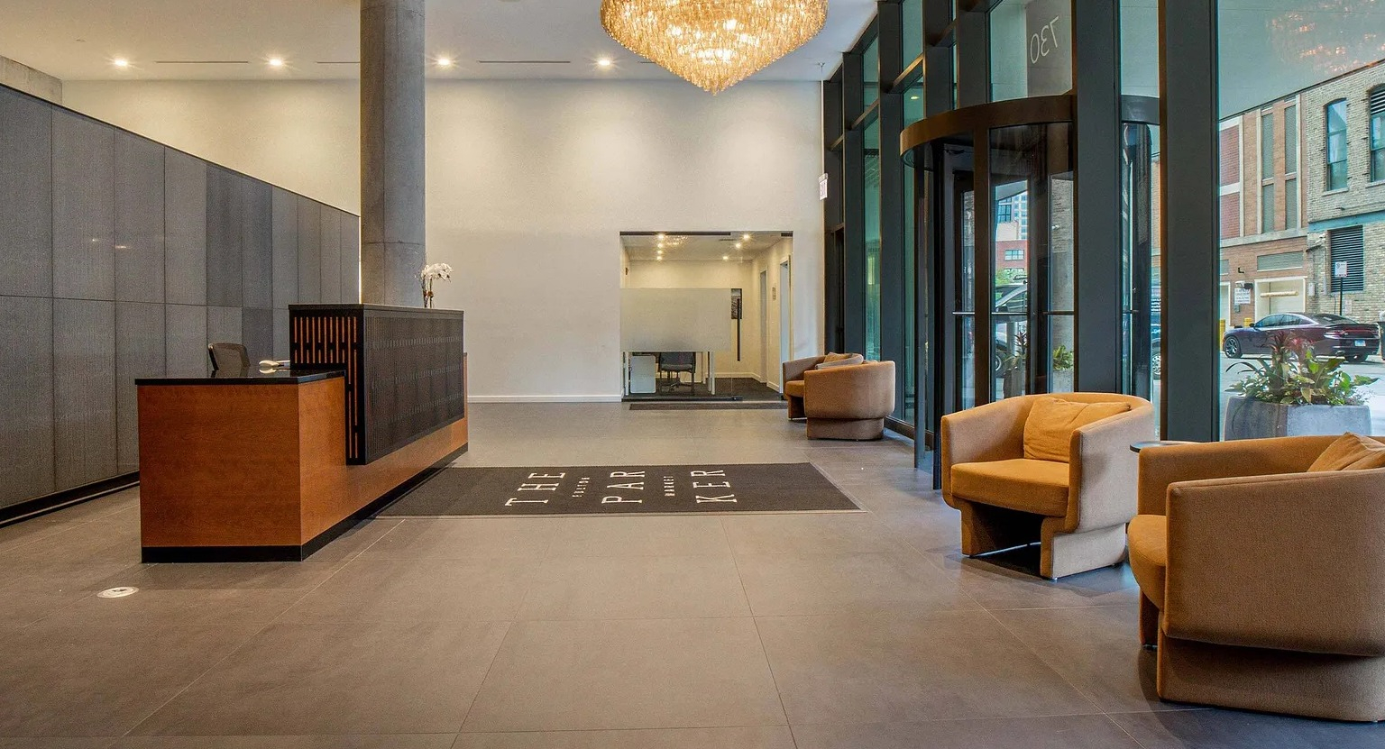 The grand and luxurious lobby entrance of The Parker Fulton Market, featuring a stylish reception desk, modern lighting, and comfortable seating in Chicago