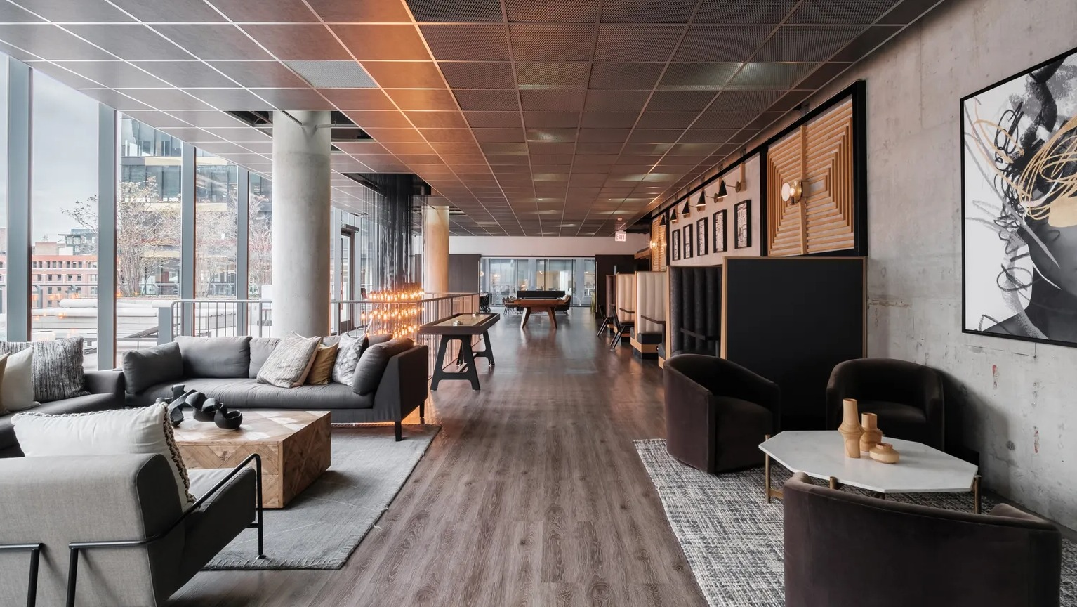 A luxurious resident lounge featuring comfortable seating, modern art, and a billiards table, perfect for relaxation at The Parker Fulton Market in Chicago