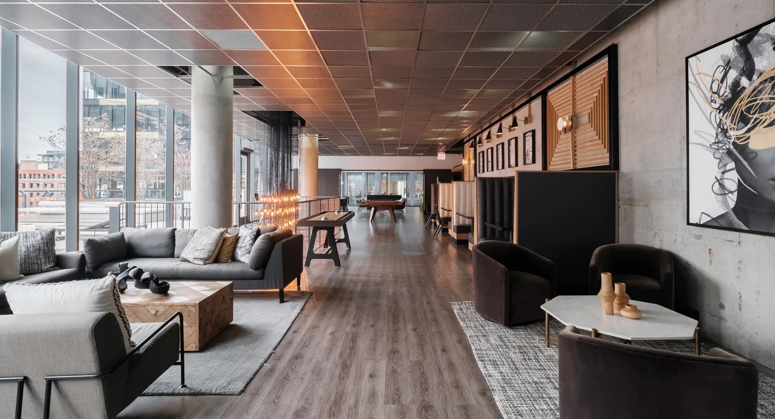 A luxurious resident lounge featuring comfortable seating, modern art, and a billiards table, perfect for relaxation at The Parker Fulton Market in Chicago