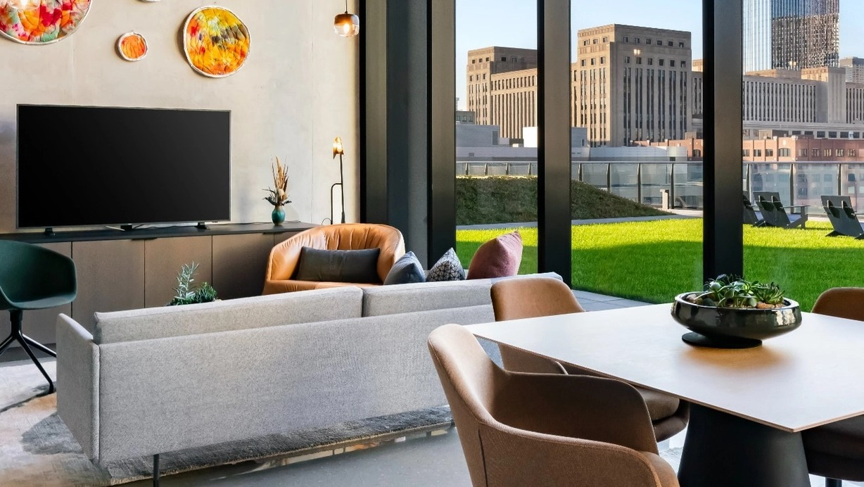 A welcoming resident lounge with comfortable seating, vibrant art, and stylish decor at The Reed apartments in Chicago.