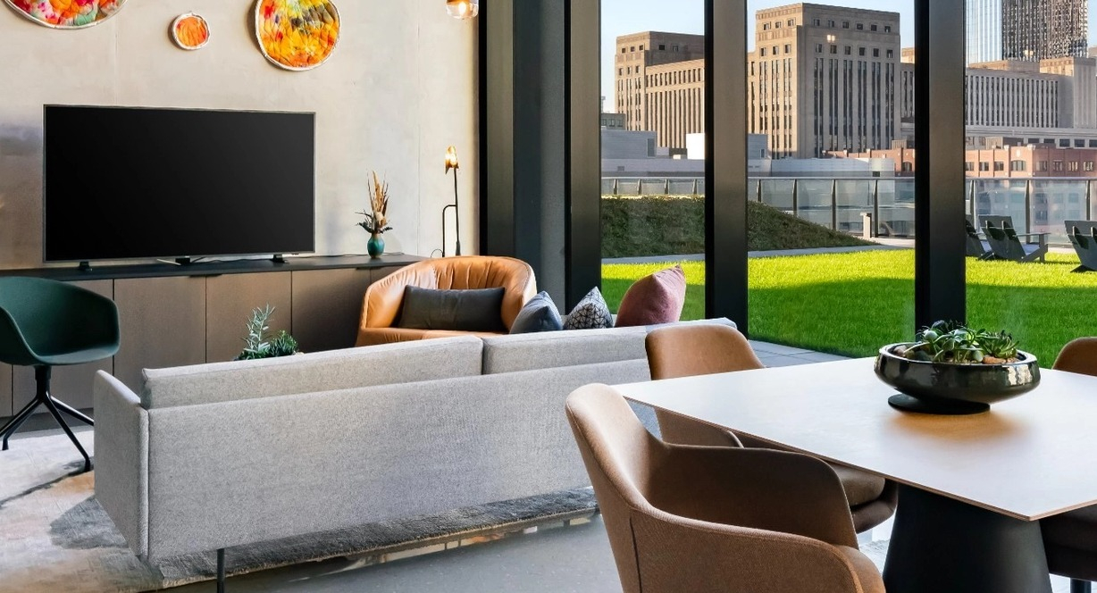 A welcoming resident lounge with comfortable seating, vibrant art, and stylish decor at The Reed apartments in Chicago.