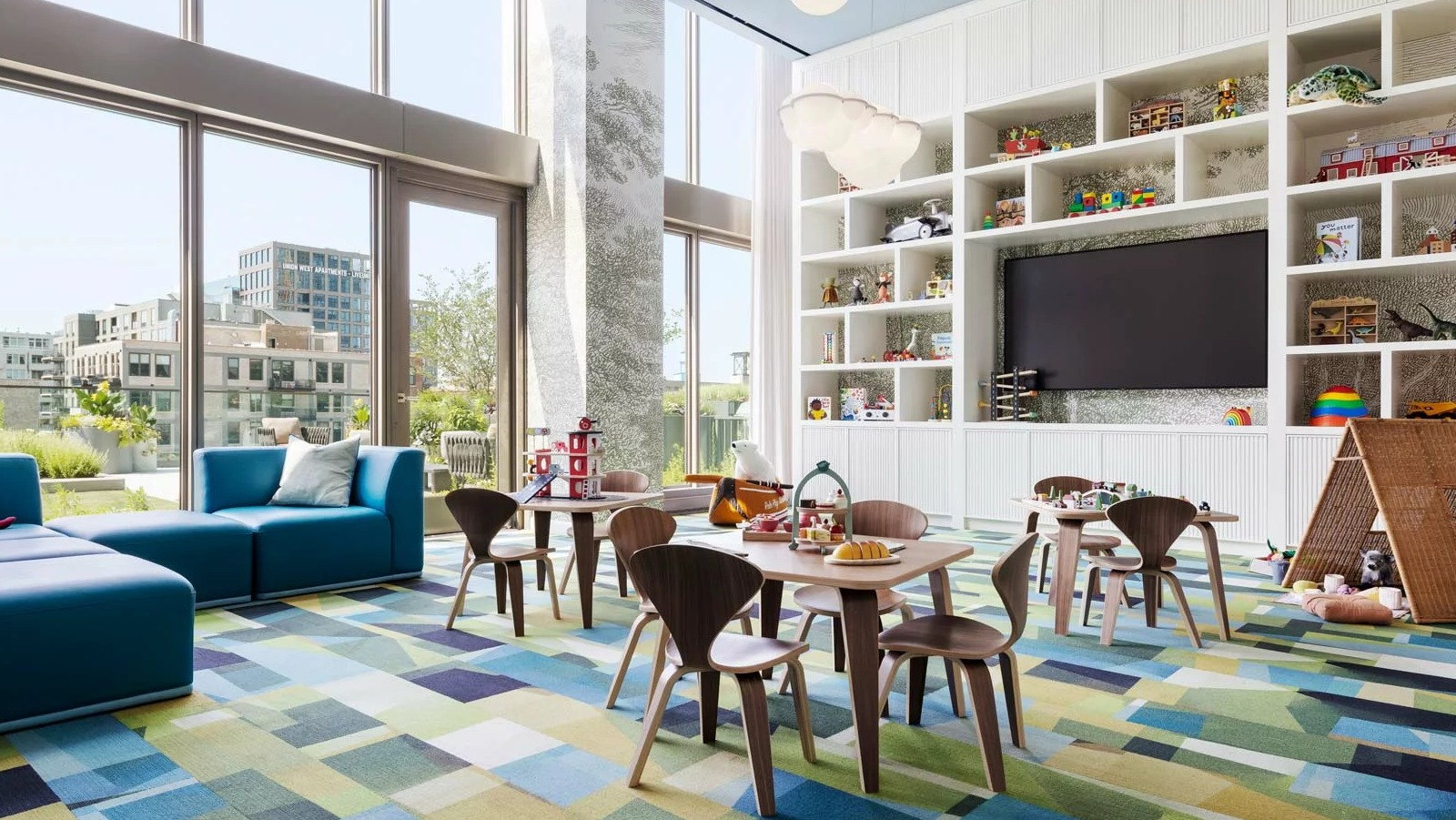 Vibrant and spacious kids' playroom at The Row Fulton Market in Chicago, featuring colorful rugs, toys, and large windows