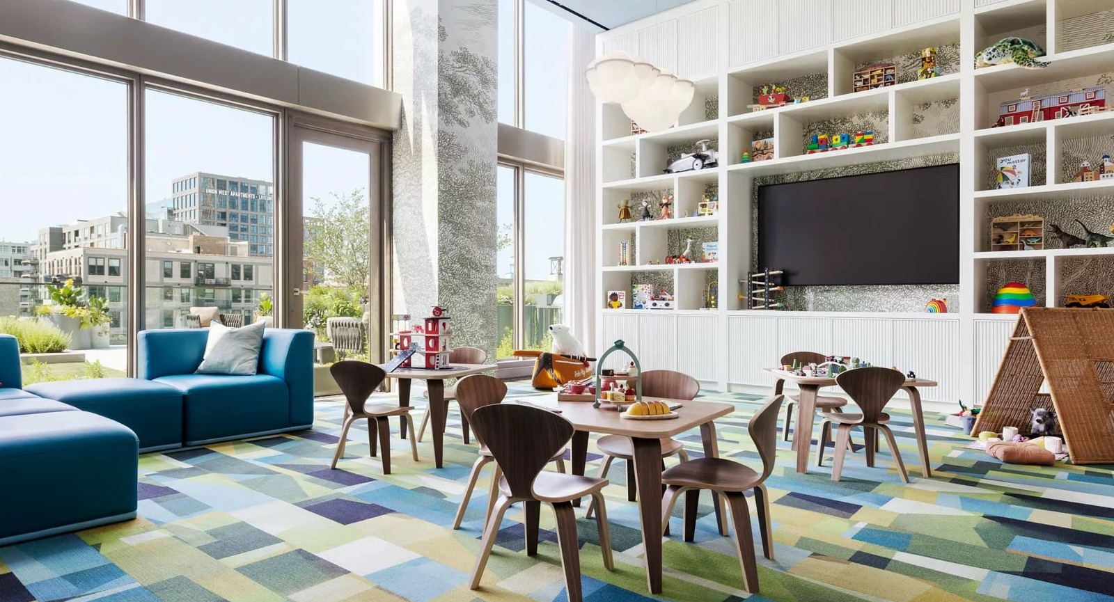 Vibrant and spacious kids' playroom at The Row Fulton Market in Chicago, featuring colorful rugs, toys, and large windows