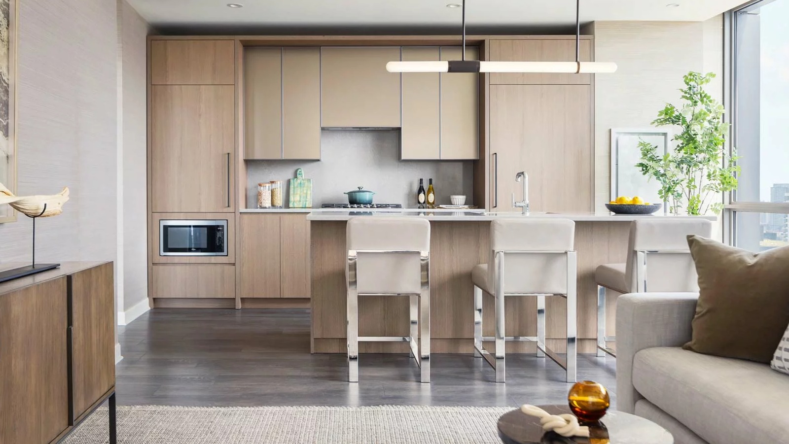Spacious open-concept kitchen and living room at The Row Fulton Market in Chicago, featuring light wood cabinets, an island, and modern furniture