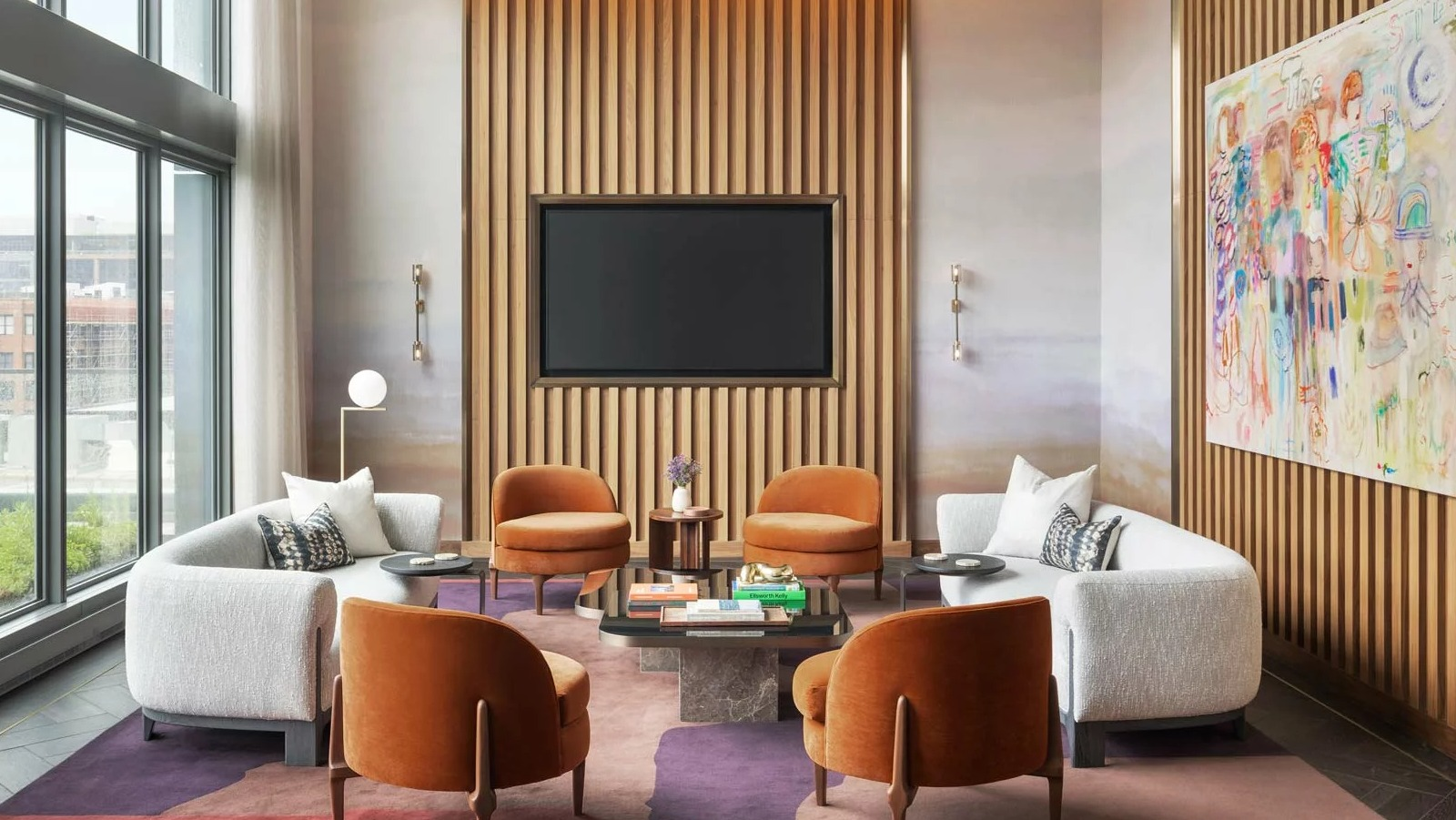 Chic media lounge at The Row Fulton Market in Chicago, featuring comfortable seating, a large TV, and vibrant modern art