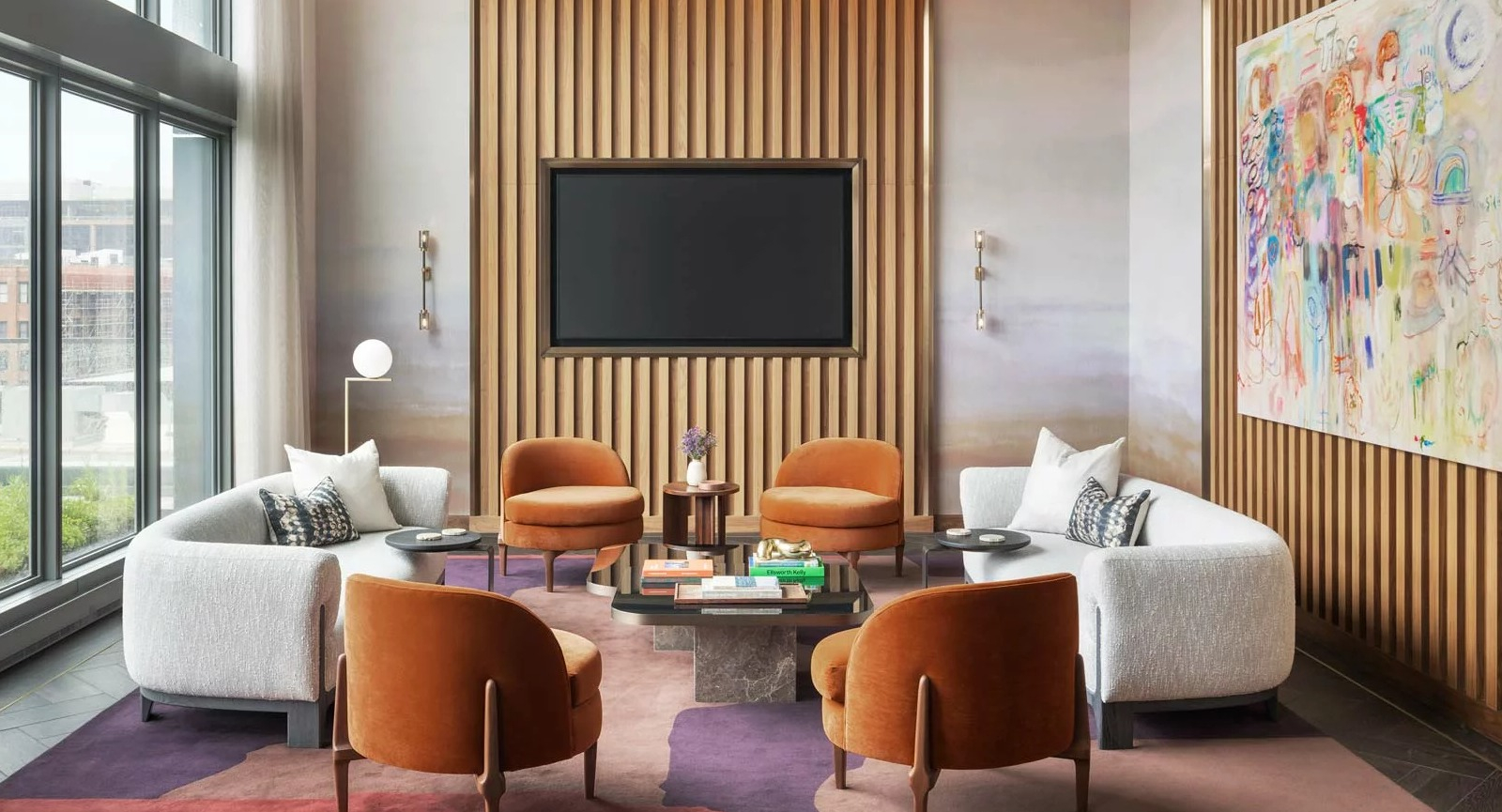 Chic media lounge at The Row Fulton Market in Chicago, featuring comfortable seating, a large TV, and vibrant modern art