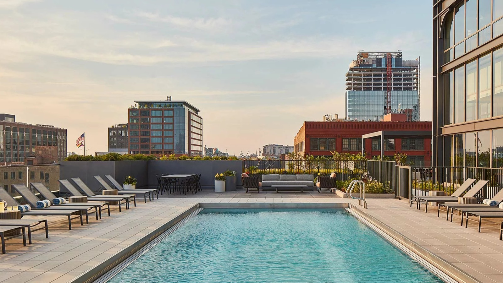 Serene rooftop swimming pool at The Row Fulton Market in Chicago, surrounded by lounge chairs and offering city views