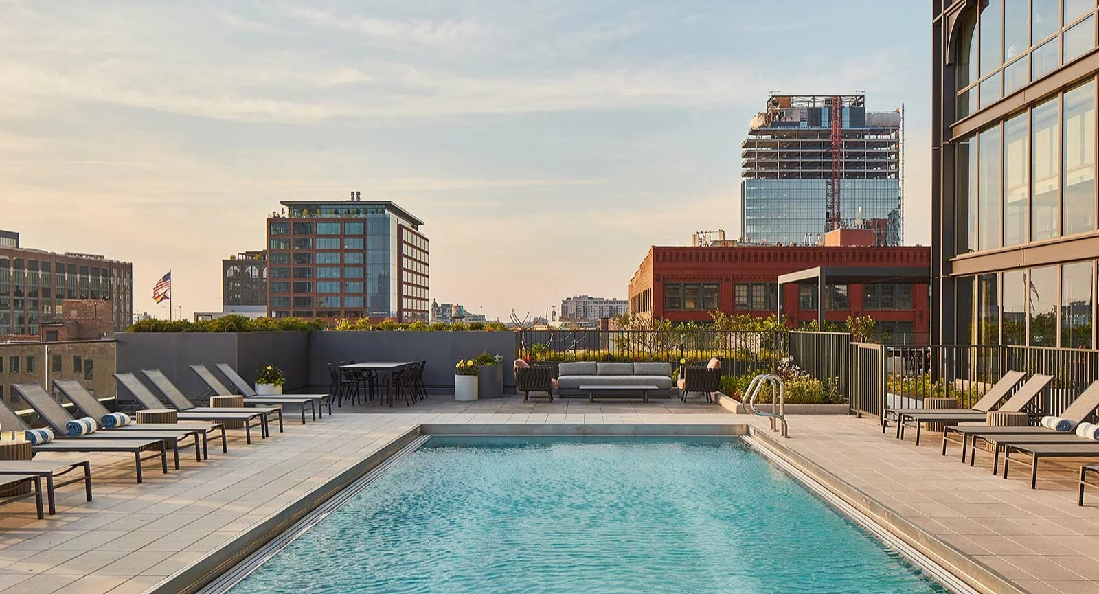 Serene rooftop swimming pool at The Row Fulton Market in Chicago, surrounded by lounge chairs and offering city views