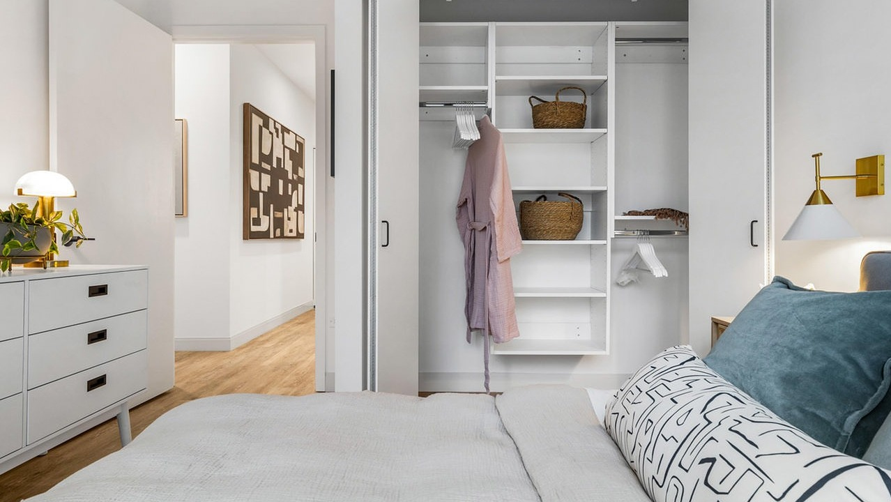 Stylish bedroom at The Saint Grand in Chicago, featuring a comfortable bed, modern decor, and a convenient walk-in closet