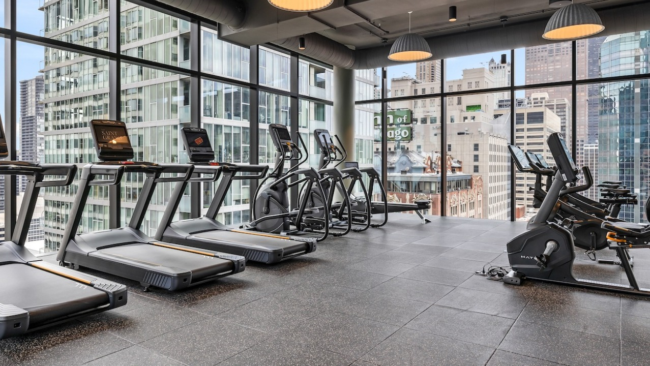 State-of-the-art cardio gym at The Saint Grand in Chicago, featuring treadmills, ellipticals, and stunning city skyline views