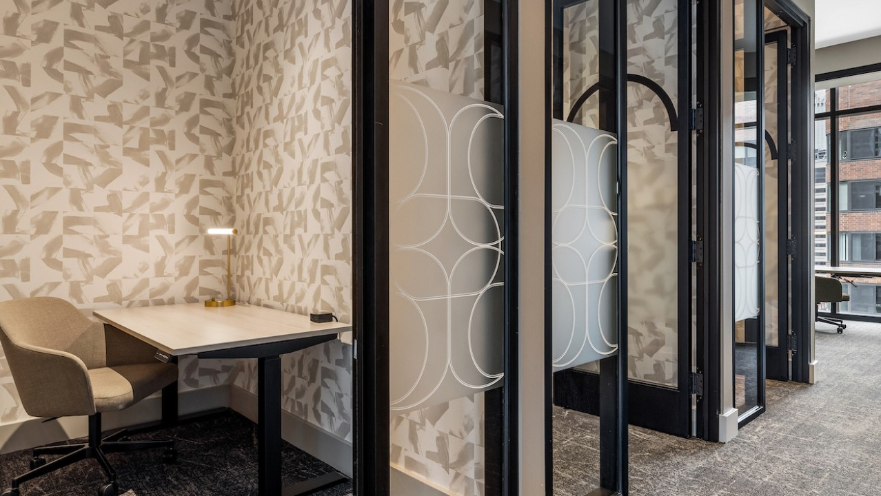 Modern co-working space at The Saint Grand in Chicago, featuring private booths, individual desks, and stylish patterns