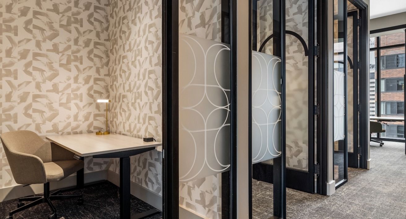 Modern co-working space at The Saint Grand in Chicago, featuring private booths, individual desks, and stylish patterns