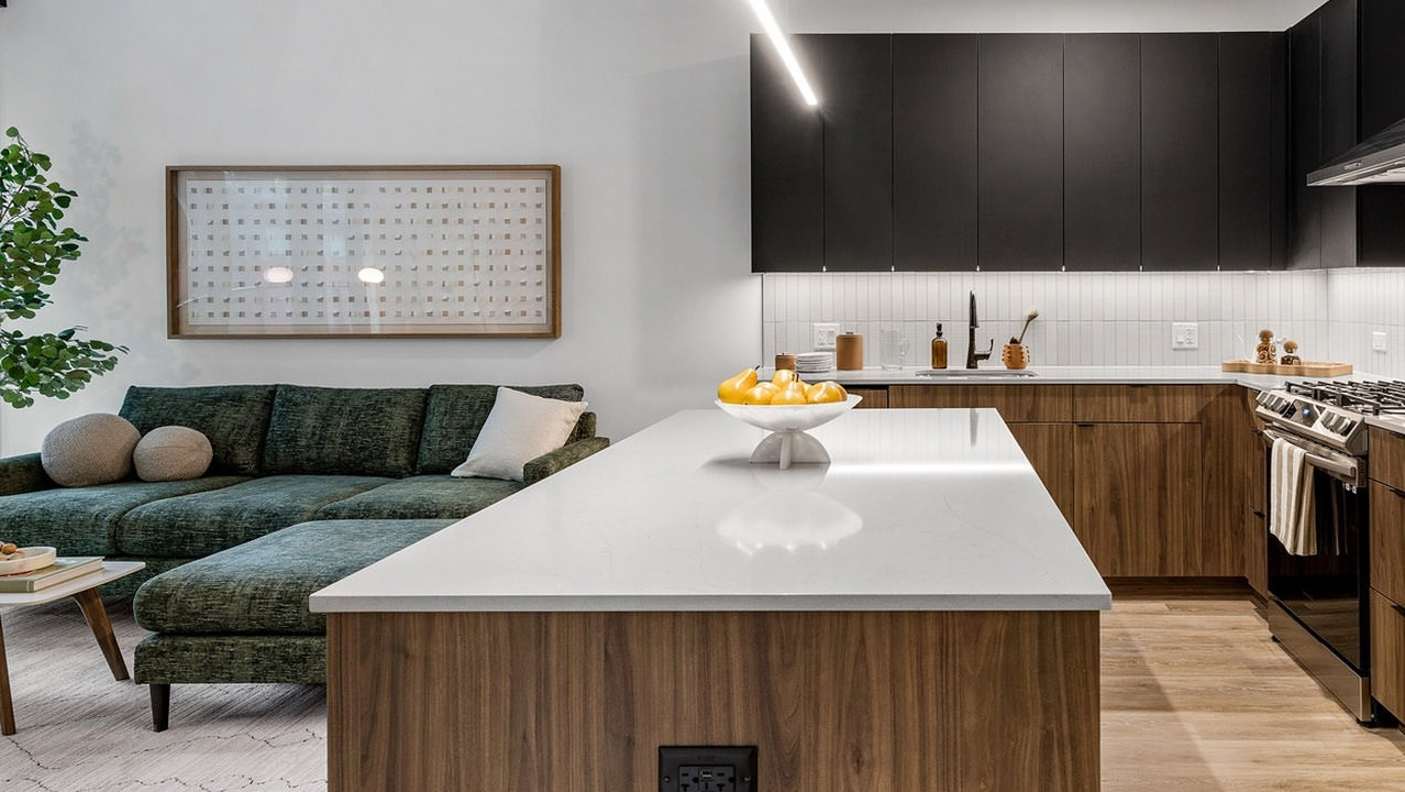 Contemporary open-concept living room and kitchen at The Saint Grand in Chicago, featuring a plush sofa, modern island, and elegant decor