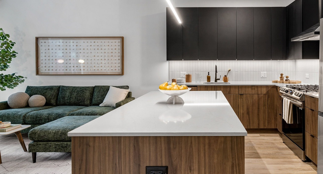 Contemporary open-concept living room and kitchen at The Saint Grand in Chicago, featuring a plush sofa, modern island, and elegant decor