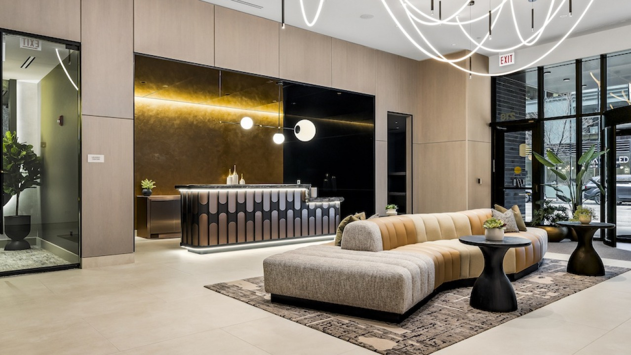 Luxurious and inviting lobby with unique lighting, a chic reception desk, and comfortable curved seating at The Saint Grand in Chicago
