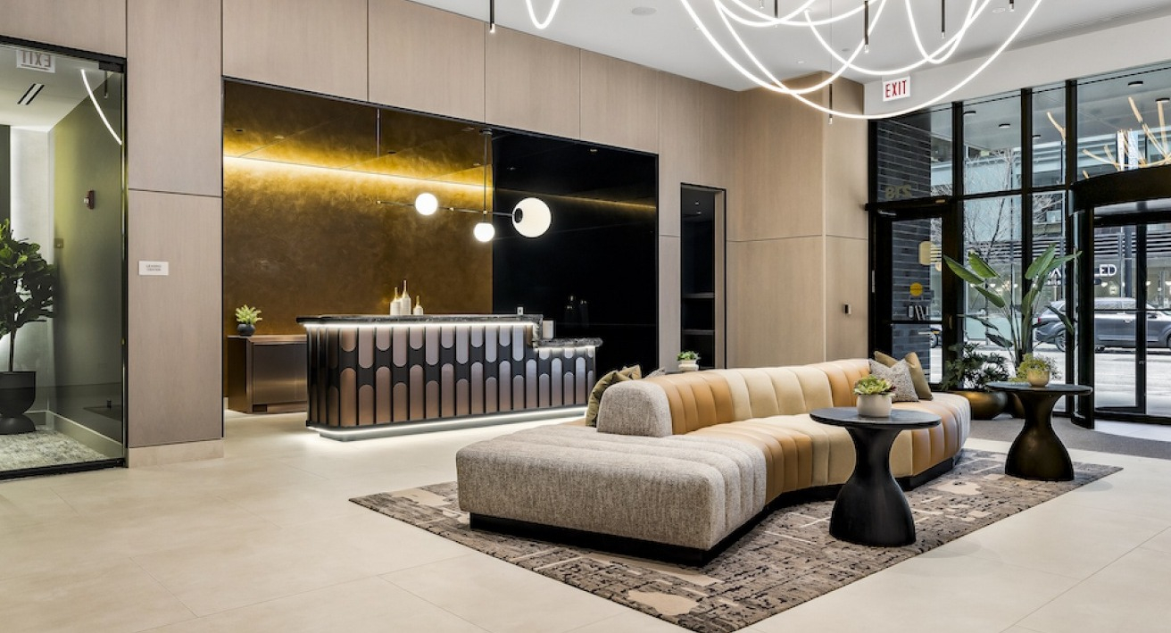 Luxurious and inviting lobby with unique lighting, a chic reception desk, and comfortable curved seating at The Saint Grand in Chicago
