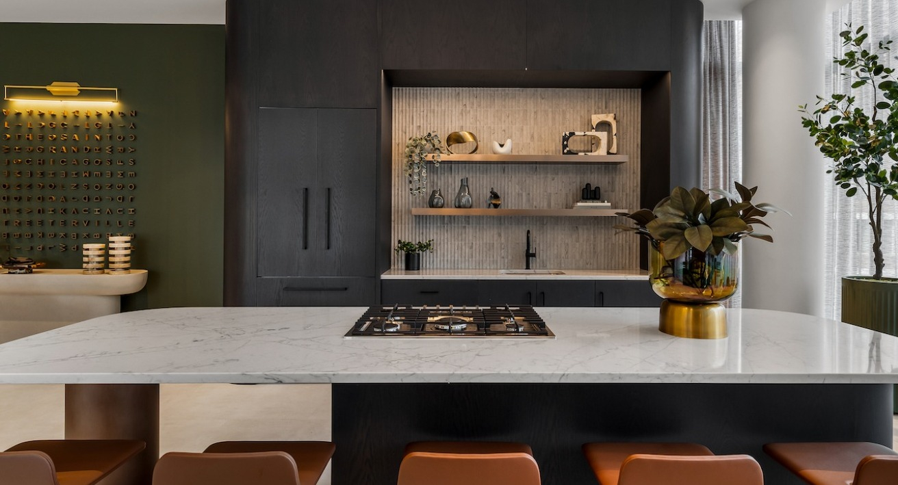 Expansive resident kitchen and dining area at The Saint Grand in Chicago, featuring a large island with a gas range and bar seating