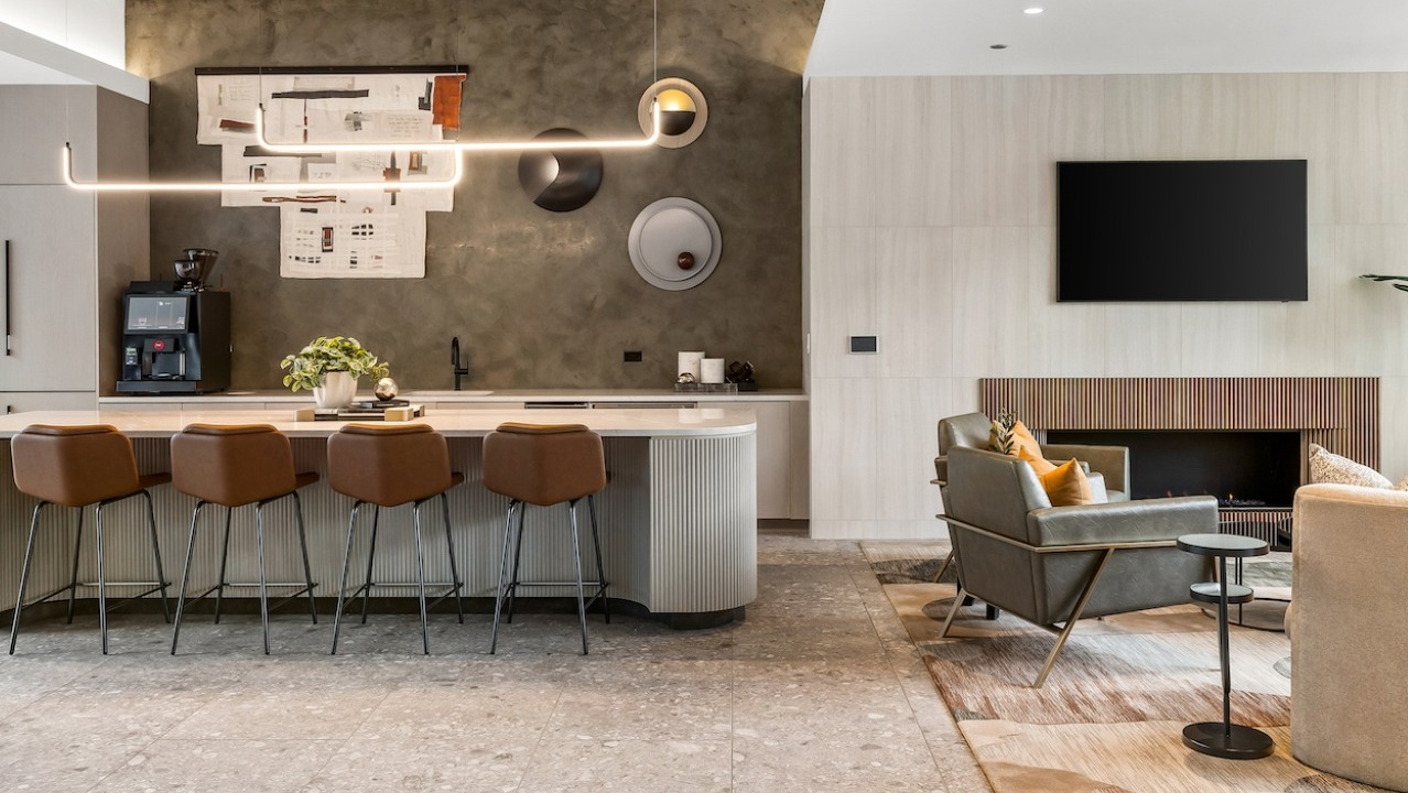 Luxurious resident lounge at The Saint Grand in Chicago, featuring a cozy fireplace, comfortable seating, and a stylish kitchen island