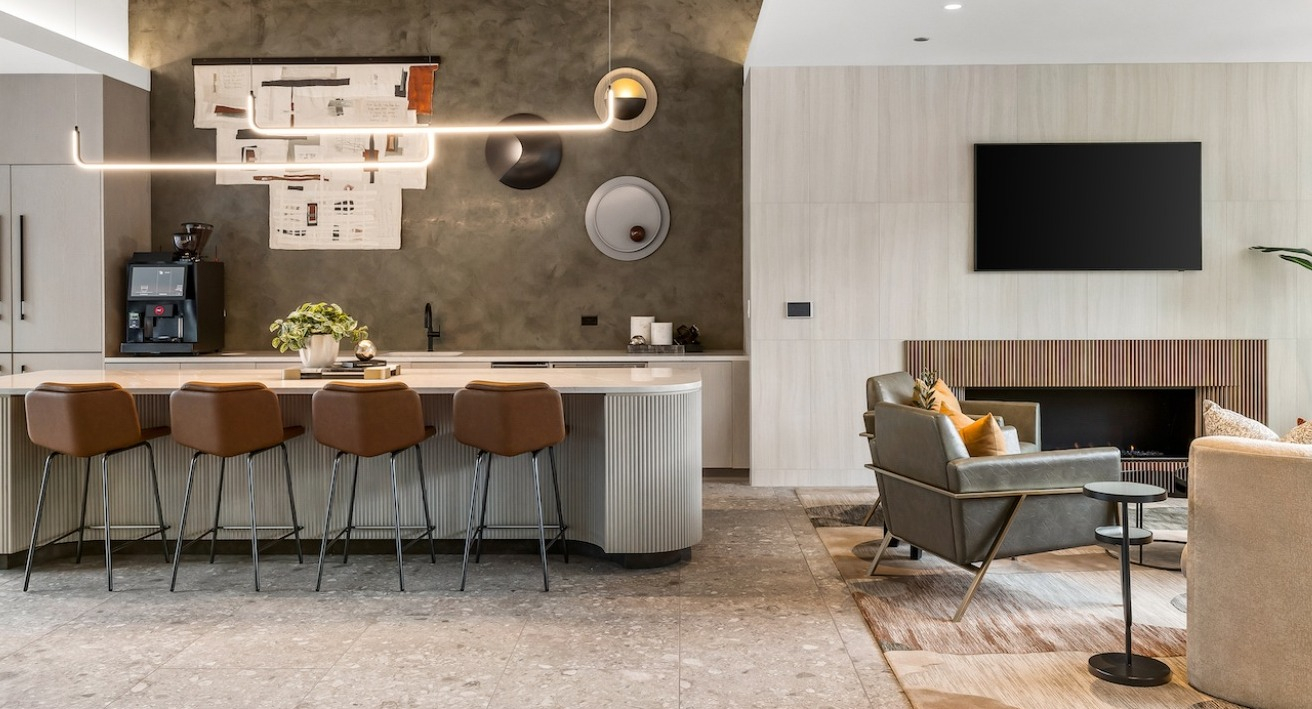 Luxurious resident lounge at The Saint Grand in Chicago, featuring a cozy fireplace, comfortable seating, and a stylish kitchen island