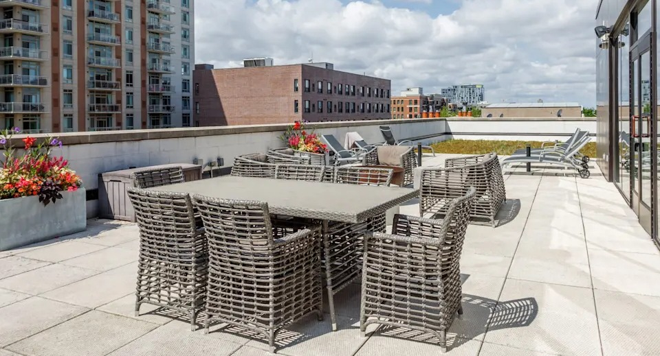 Spacious rooftop patio with outdoor seating and lounge chairs, offering open-air relaxation and city views at The Scott Residences in Chicago