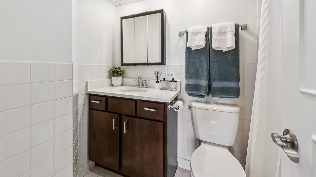 Bright bathroom at The Seneca Apartments in Chicago, featuring a modern vanity, subway tiles, and ample lighting