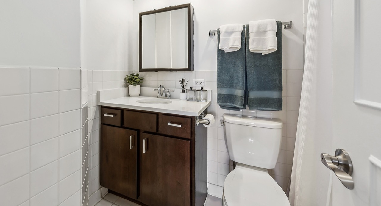 Bright bathroom at The Seneca Apartments in Chicago, featuring a modern vanity, subway tiles, and ample lighting