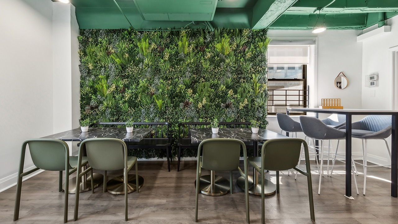 Unique co-working space at The Seneca Apartments in Chicago, featuring a vertical garden wall, communal tables, and modern chairs