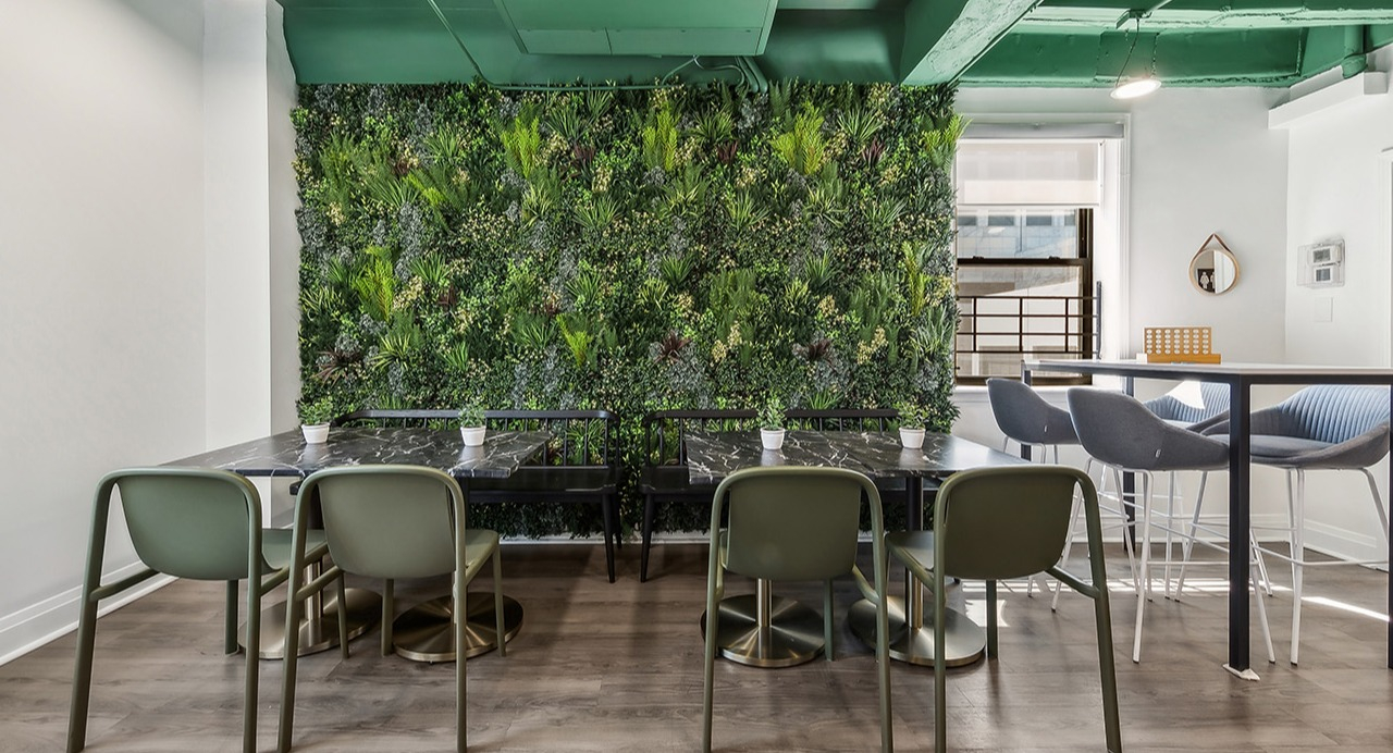 Unique co-working space at The Seneca Apartments in Chicago, featuring a vertical garden wall, communal tables, and modern chairs